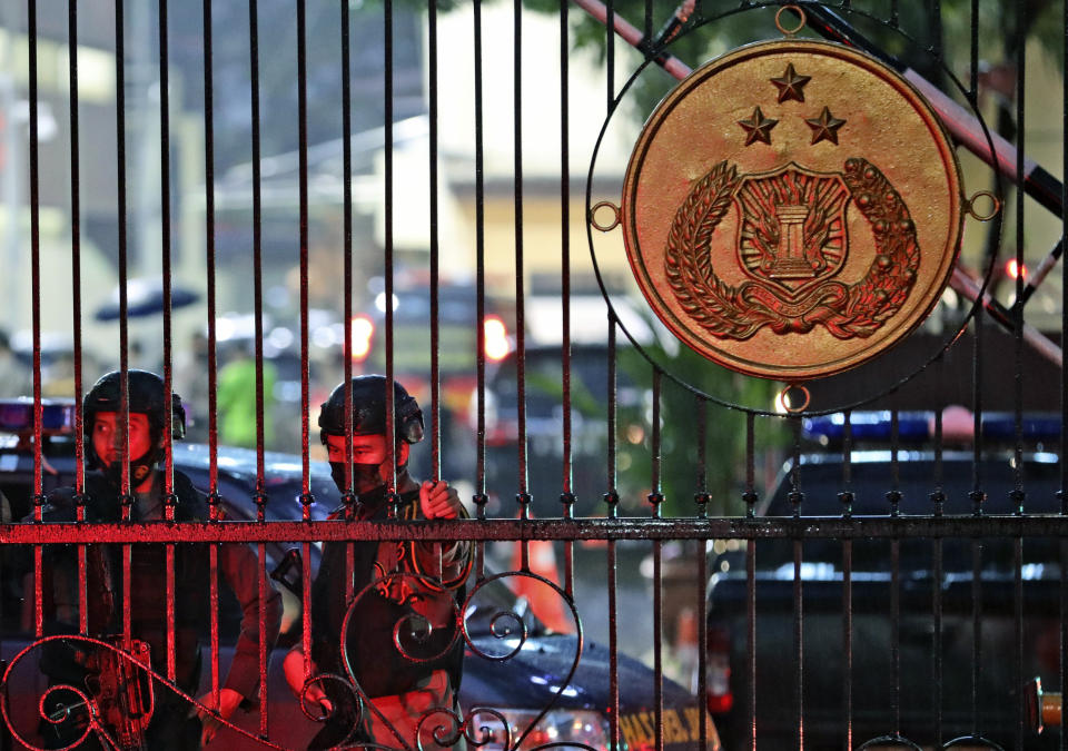 Police officers stand guard at the main gate of the National Police Headquarters following a suspected militant attack in Jakarta, Indonesia, Wednesday, March 31, 2021. A woman entered the Indonesian National Police Headquarters in Jakarta and pointed a gun at several officers before being shot dead by police, in the latest in a series of suspected militant attacks in the world's most populous Muslim nation. (AP Photo/Dita Alangkara)