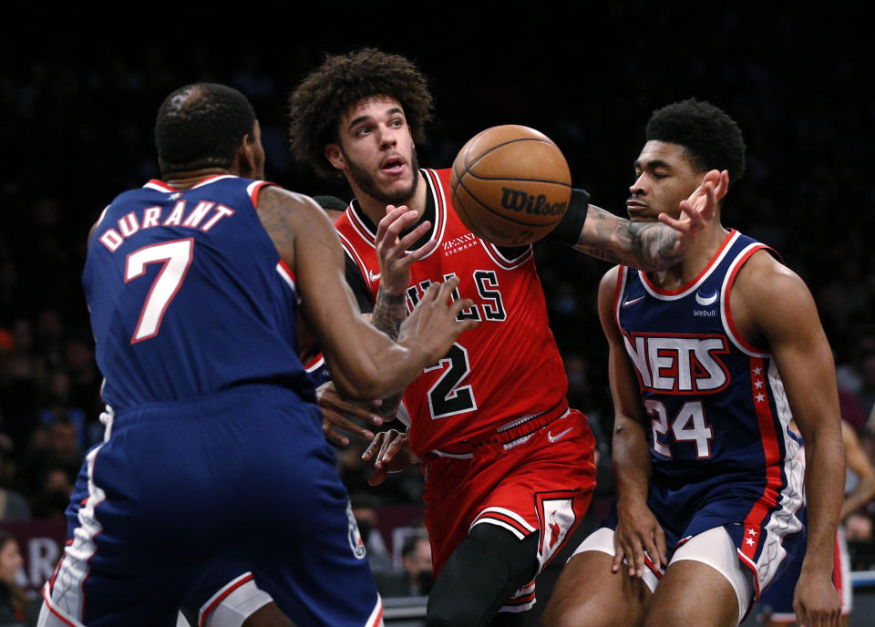 Chicago Bulls guard Lonzo Ball (2) loses the ball between Brooklyn Nets defenders Kevin Durant (7) and Cam Thomas (24) during the first half of an NBA basketball game in New York, Saturday, Dec. 4, 2021. (AP Photo/Noah K. Murray)