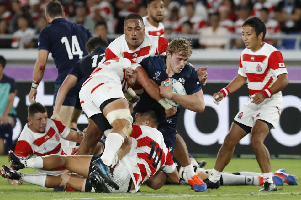 Scotland's Jonny Gray is tacked by Japan's defense during the Rugby World Cup Pool A game at International Stadium between Japan and Scotland in Yokohama, Japan, Sunday, Oct. 13, 2019. (AP Photo/Eugene Hoshiko)