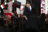 Incumbent President Andrzej Duda shakes hands with supporters in Pultusk, Poland, Sunday, July 12, 2020. An exit poll in Poland's presidential runoff election shows a tight race that is too close to call between the conservative incumbent, Andrzej Duda, and the liberal Warsaw mayor, Rafal Trzaskowski.(AP Photo/Czarek Sokolowski)