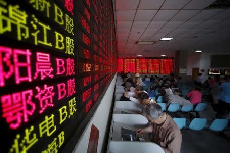 Investors look at computer screens showing stock information at a brokerage house in Shanghai, May 26, 2015. REUTERS/Aly Song