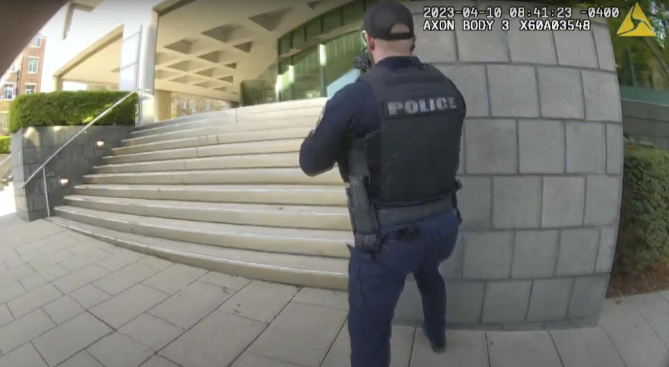 In this screen grab taken from the body cam video of Louisville Metro Police Department Officer Nickolas Wilt, fellow Officer Cory Galloway approaches an active shooting situation, with Wilt following behind him, at Old National Bank, in Louisville, Ky., Monday, April 10, 2023. (Louisville Metro Police Department via AP)