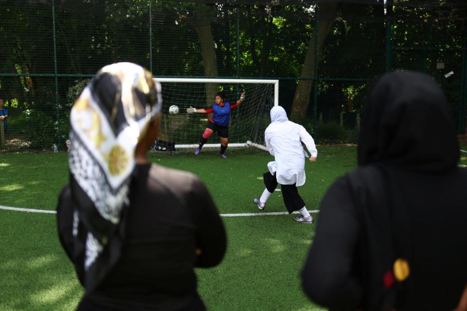 Faezeh scores a penalty during a friendly football match (Reuters)