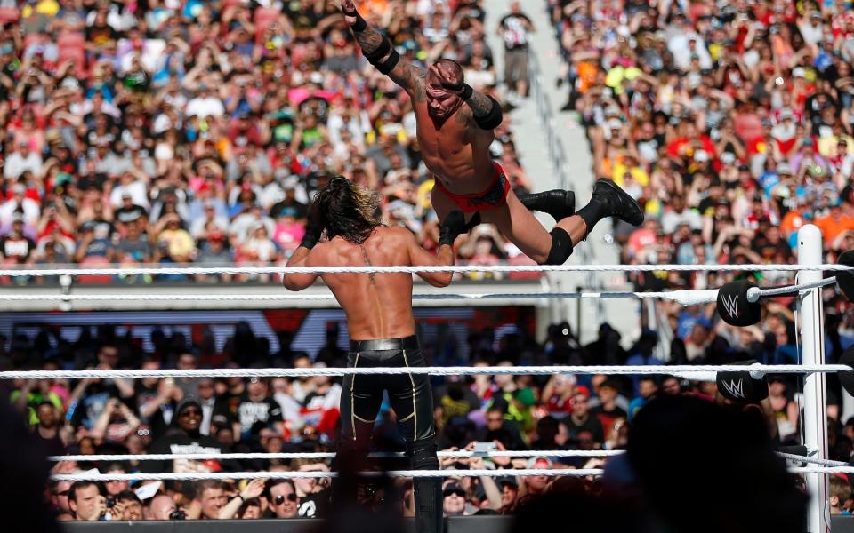 WWE's Randy Orton, right, dives at Seth Rollins during WrestleMania at Levi's Stadium in California, 2015 - Credit: Tribune Content Agency LLC / Alamy Stock Photo/Tribune Content Agency LLC / Alamy Stock Photo