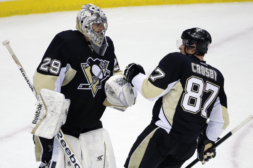 Pittsburgh Penguins goalie Marc-Andre Fleury (29) celebrates with Sidney Crosby (87) after a 4-3 win over the Columbus Blue Jackets in a first-round NHL playoff hockey game in Pittsburgh on Wednesday, April 16, 2014.(AP Photo/Gene J. Puskar)