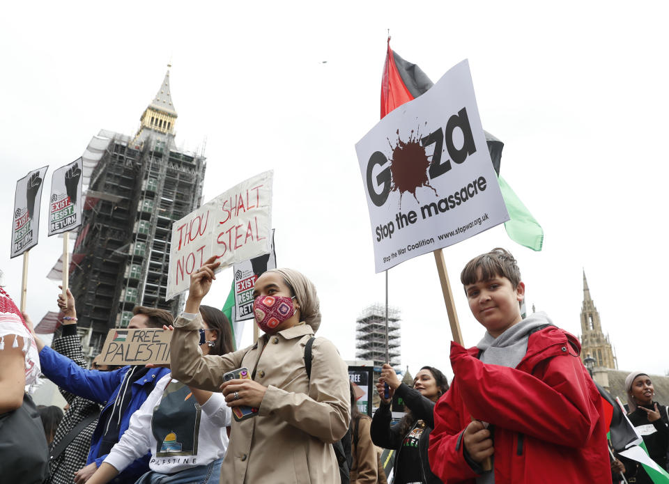 Protesters hold placards and banners in London, Saturday, May 22, 2021, as they take part in a rally supporting Palestinians. Egyptian mediators held talks Saturday to firm up an Israel-Hamas cease-fire as Palestinians in the Hamas-ruled Gaza Strip began to assess the damage from 11 days of intense Israeli bombardment. (AP Photo/Alastair Grant)