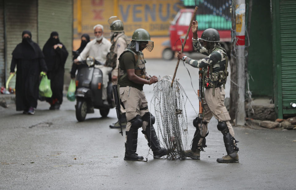 FILE-In this Aug. 10, 2019, file photo, Indian paramilitary soldiers prepare to close off a street with barbwire in Srinagar, Indian controlled Kashmir. The beautiful Himalayan valley is flooded with soldiers and roadblocks of razor wire. Phone lines are cut, internet connections switched off, politicians arrested. Narendra Modi, the prime minister of the world’s largest democracy has clamped down on Kashmir to near-totalitarian levels. (AP Photo/Mukhtar Khan, file)