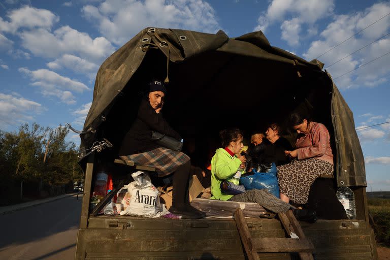 Refugiados sentados en la parte trasera de un camión con sus pertenencias cargadas cerca de Kornidzor el 28 de septiembre de 2023. (Foto de ALAIN JOCARD / AFP)