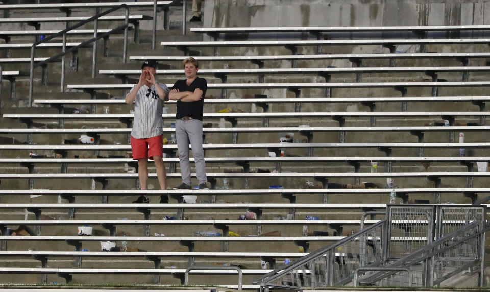 FILE - In this Aug. 2, 2017, file photo, baseball fans cheer from the right field bleacher seats after a rain delay in a baseball game between the New York Yankees and the Detroit Tigers in New York. The crippling grip the coronavirus pandemic has had on the sports world has forced universities, leagues and franchises to evaluate how they might someday welcome back fans. (AP Photo/Julie Jacobson, File)