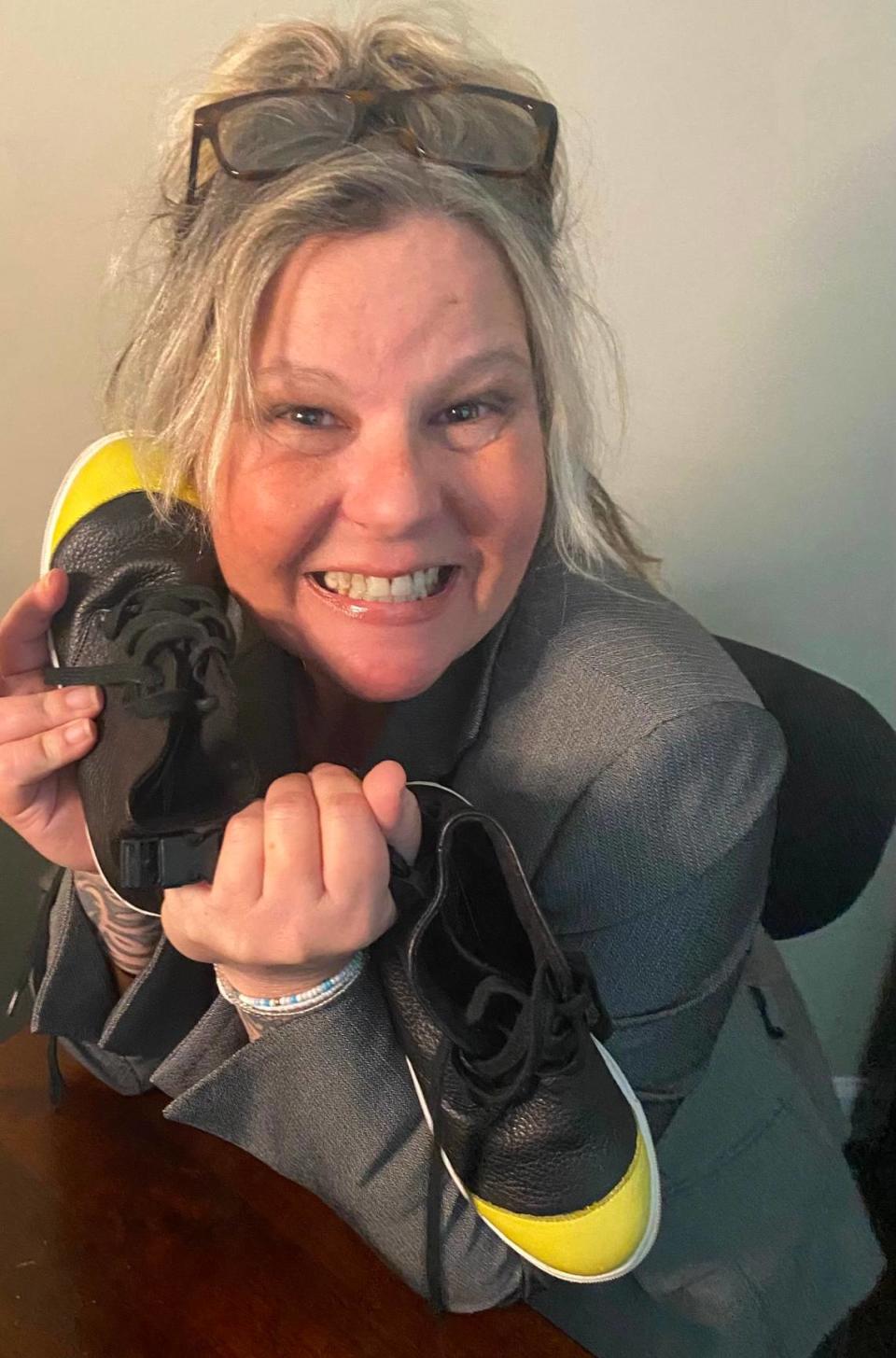Sharyn Horewitch now lives outside Charlotte and has her own company — NYOS LLC, which stands for Not Your Ordinary Shoe. She’s posing with with a prototype of a new type of shoe she developed that can’t be easily removed.