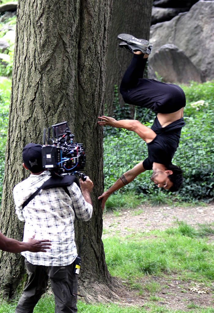 Taylor Lautner flipping around against a tree at