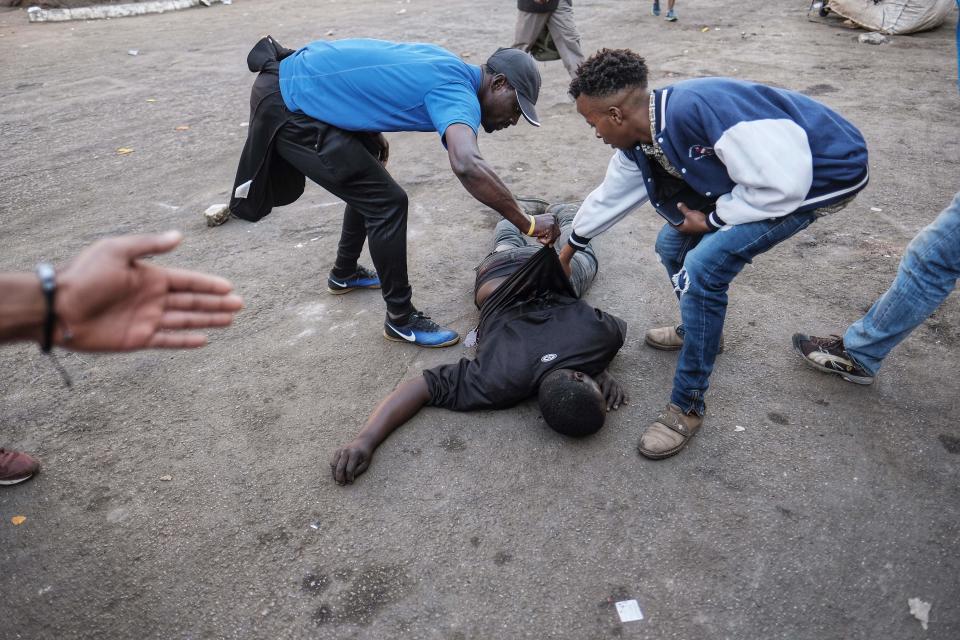 <p>A man lies on the ground after the Zimbabwean army opened fire in central Harare on August 1, 2018 as protests erupted over alleged fraud in the country’s election. – The man died after being shot in the stomach, an AFP photographer said, confirming that he died at the scene. President Emmerson Mnangagwa on August 1 called for peace as police fired water cannon and teargas at opposition supporters in Harare over alleged fraud in Zimbabwe’s elections. (Photo: Marco Longari/AFP/Getty Images) </p>