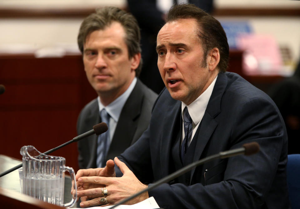 CORRECTS SPELLING OF NICOLAS - Actor Nicolas Cage testified in support of a bill proposing tax incentives to filmmakers at the Legislative Building Carson City, Nev., on Tuesday, May 7, 2013. Proponents of the measure say it will bring jobs and revenue to the state. Cage's agent Michael Nilon is at left. (AP Photo/Cathleen Allison)