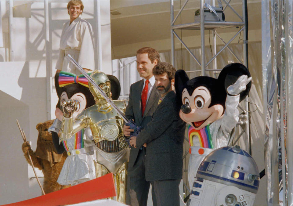 <p>Disney chairman Michael Eisner and <i>Star Wars</i> creator George Lucas prepared to use a lightsaber to cut the ribbon opening the new <i>Star Tours</i> attraction at Disneyland in Anaheim, California on January 9, 1987. (Photo: Bob Galbraith/AP)</p>