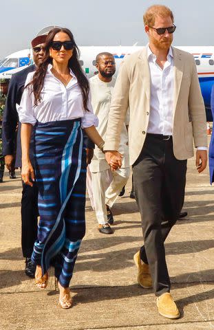 <p>Andrew Esiebo/Getty</p> Meghan Markle and Prince Harry arrive in Lagos, Nigeria on May 12, 2014.