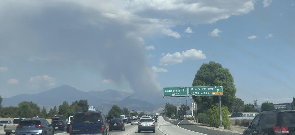 A plume of smoke from the El Dorado fire is seen from the Interstate 10 in Loma Linda, Calif., Saturday, Sept. 5, 2020. In Southern California, a fast-moving fire in the foothills of Yucaipa has prompted evacuation orders for Oak Glen, a farm community that just opened its apple-picking season to the public. Cal Fire's San Bernardino unit said the fire has scorched at least 800 acres and was burning at a "moderate to dangerous" rate of spread. (AP Photo/Ringo H.W. Chiu)