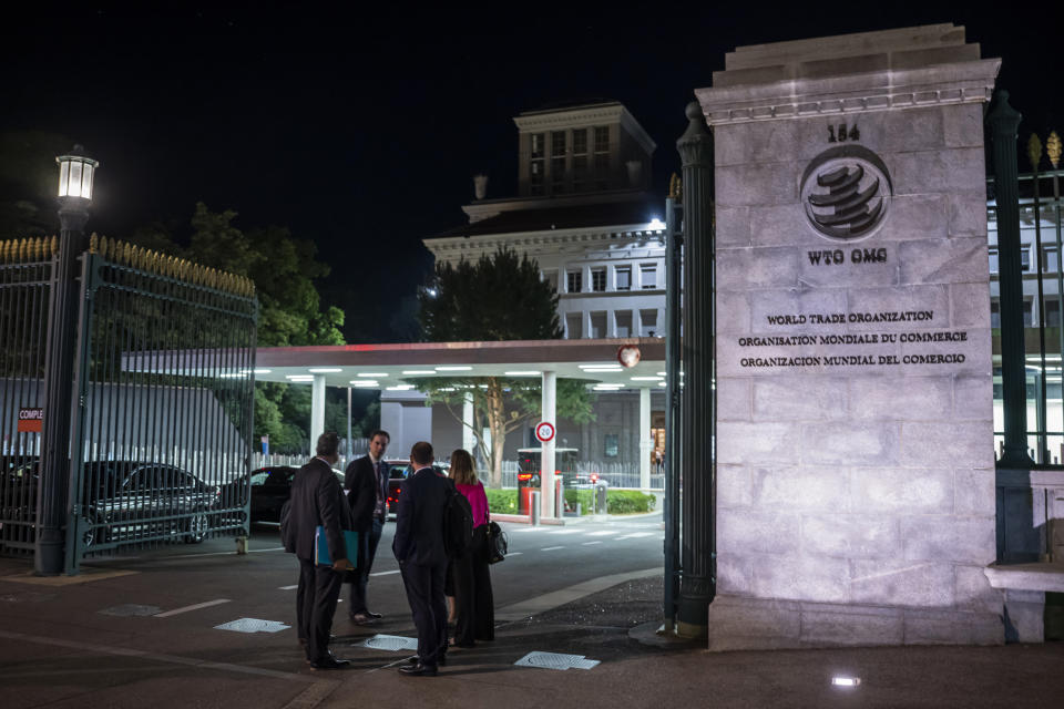 Delegation members are seen at the entrance of the World Trade Organization (WTO) headquarters during the 12th Ministerial Conference (MC12), in Geneva, Switzerland, early Friday, June 17, 2022. (Martial Trezzini/Keystone via AP)