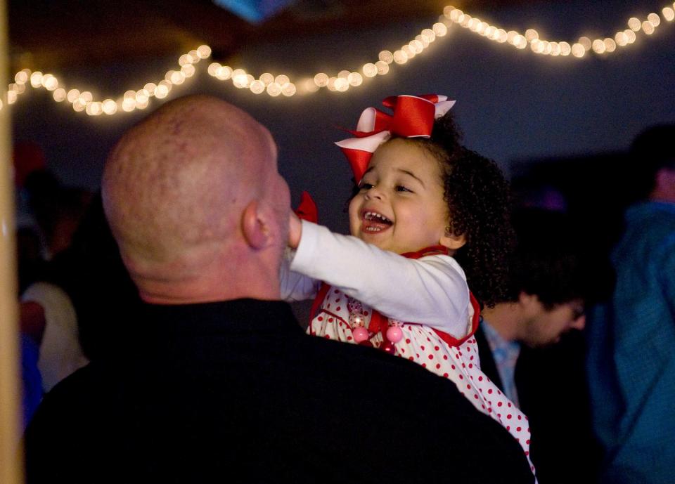 Neveah Christian, 2, laughs with her father, Robert, at a past Father-Daughter Dance at Calvary Episcopal Church in Fletcher. TIMES-NEWS FILE