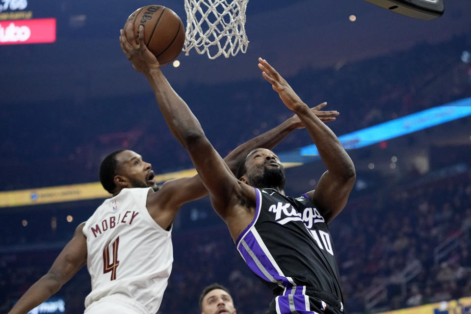 Sacramento Kings forward Harrison Barnes right, shoots in front of Cleveland Cavaliers forward Evan Mobley (4) in the first half of an NBA basketball game, Monday, Feb. 5, 2024, in Cleveland. (AP Photo/Sue Ogrocki)