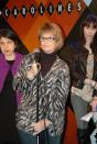 This Feb. 9, 2014 photo shows Anne D’Innocenzio, left, and Ella Steinbeck, right, watching as Robin Siegel Lakin practices with the microphone before performing at a standup comedy show at Caroline's Comedy Club in New York. (AP Photo/Lawrence Roberts)