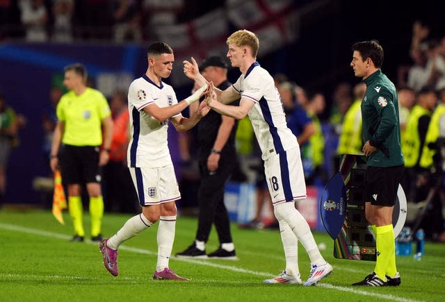 England’s Anthony Gordon high-fives Phil Foden as he replaces the Manchester City midfielder against Slovenia