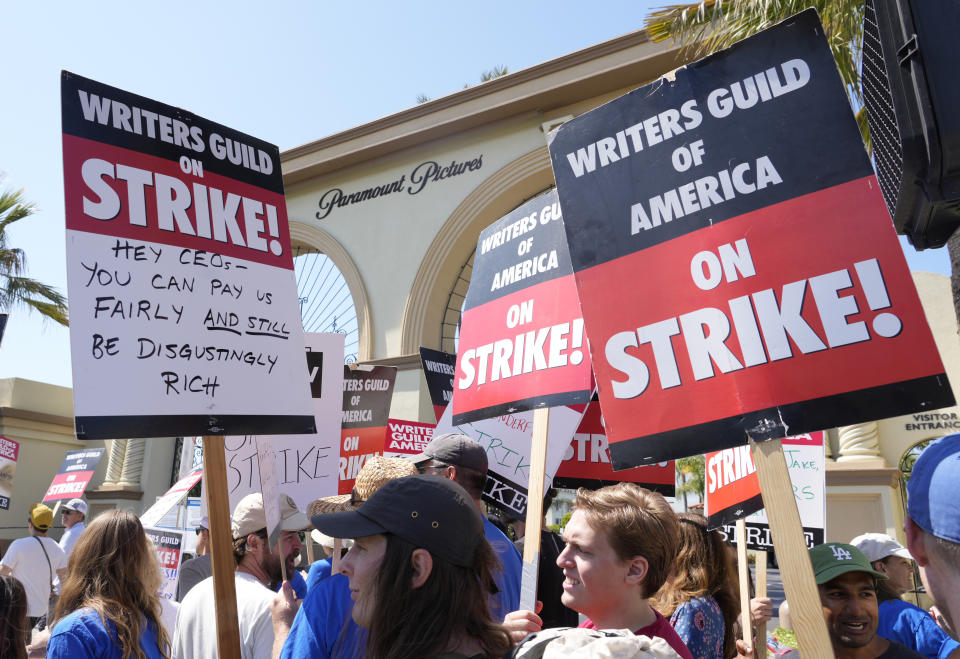 Striking Writers Guild members hold signs during a rally in front of Paramount Pictures studio in Los Angeles in May. Hollywood actors will join writers on the picket line. (AP Photo/Chris Pizzello, File)