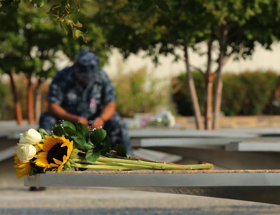 A U.S. sailor sits in the Pentagon 9/11 Memorial before the remembrance ceremonies in Washington September 11, 2013. (REUTERS/Gary Cameron)