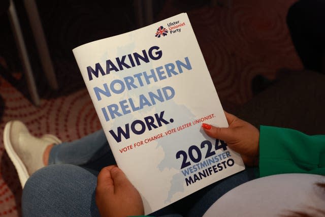 A party supporter holds the Ulster Unionist Party (UUP) manifesto