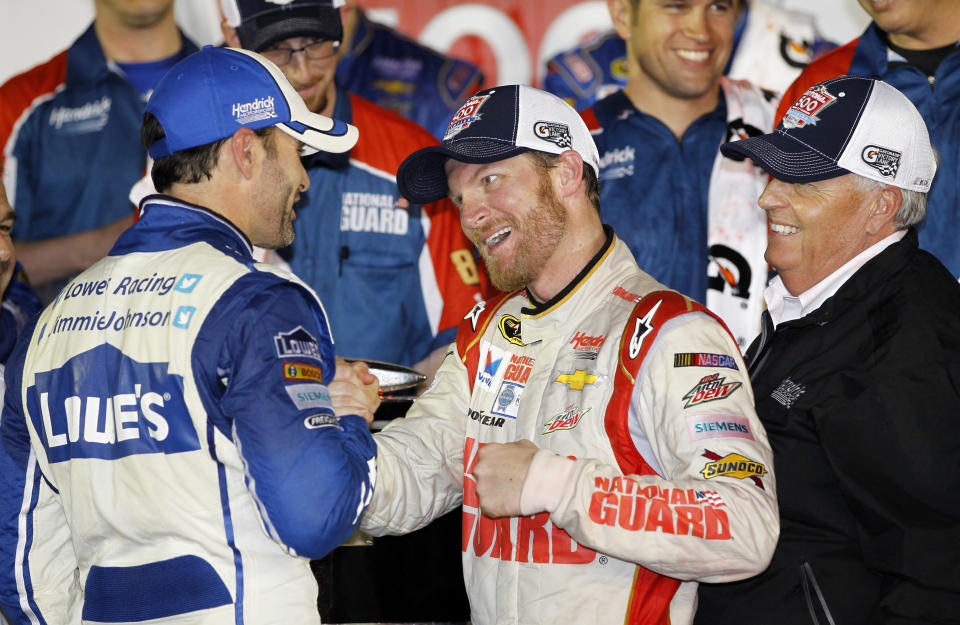 Dale Earnhardt Jr., center, celebrates in Victory Lane with teammate Jimmie Johnson, left, and team owner Rick Hendrick, right, after winning the NASCAR Daytona 500 Sprint Cup series auto race at Daytona International Speedway in Daytona Beach, Fla., Sunday, Feb. 23, 2014. (AP Photo/Terry Renna)