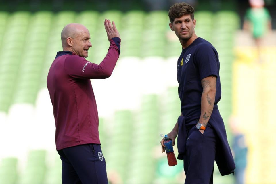 Stones in conversation with England’s interim manager Lee Carsley (The FA/Getty)