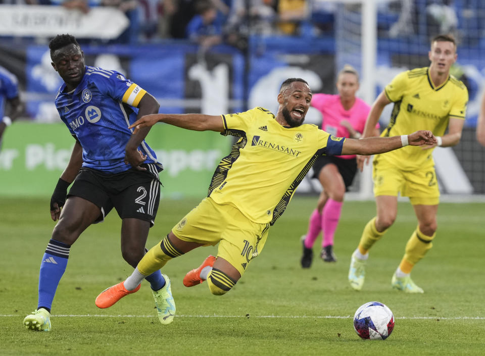 Nashville SC midfielder Hany Mukhtar, center, and CF Montreal midfielder Victor Wanyama (2) vie for the ball during the first half of an MLS soccer match Wednesday, June 21, 2023, in Montreal. (Christinne Muschi/The Canadian Press via AP)