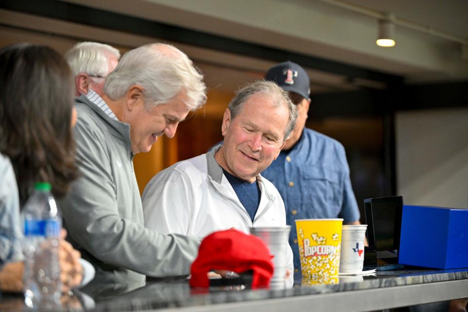 Apr 27, 2024; Arlington, Texas, USA; Former president George W. Bush checks out a Texas Rangers world series championship ring during the game between the Texas Rangers and the Cincinnati Reds at Globe Life Field. Mandatory Credit: Jerome Miron-USA TODAY Sports