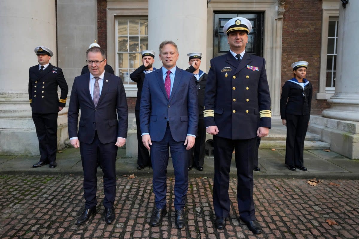 British Defense Secretary Grant Shapps, center, poses with Ukrainian Vice Admiral Oleksii Neizhpapa, right, and Norwegian Defense Minister Bjorn Arild Gram in London in December  (AP)