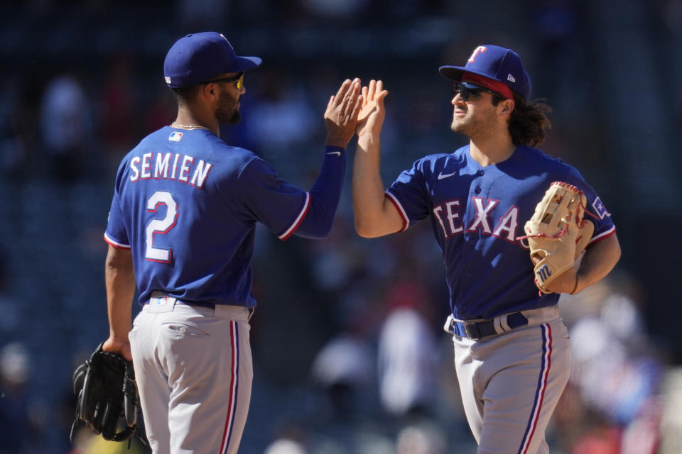 Texas Rangers second baseman Marcus Semien (2) and shortstop Josh Smith (47) celebrate after a 16-8 win over the Los Angeles Angels in a baseball game in Anaheim, Calif., Sunday, May 7, 2023. (AP Photo/Ashley Landis)
