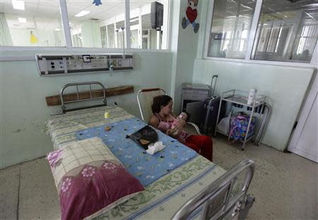 Marilina Barcesia, who is four-month's-old, rests in the arms of her mother at the William Soler Children's Heart Center as she waits for surgery in Havana October 7, 2013. REUTERS/Desmond Boylan