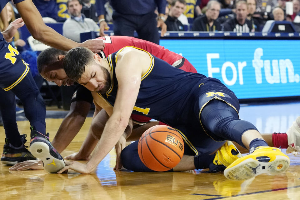 Michigan center Hunter Dickinson (1) and Ohio State forward Zed Key chase the loose ball during the first half of an NCAA college basketball game, Sunday, Feb. 5, 2023, in Ann Arbor, Mich. (AP Photo/Carlos Osorio)