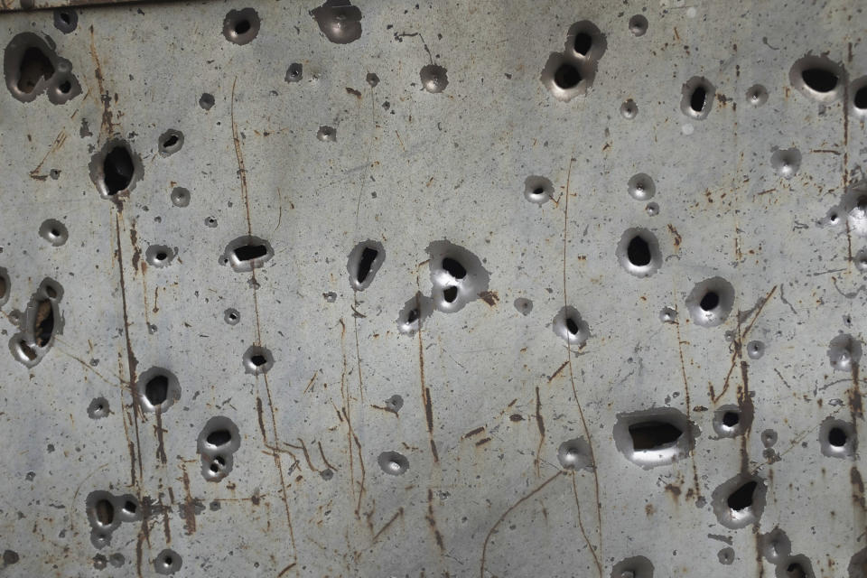 Shrapnel holes are seen in a fence in Hadrut province of self-proclaimed Republic of Nagorno-Karabakh, Azerbaijan, Thursday, Oct. 1, 2020. Two French and two Armenian journalists have been injured in the South Caucasus separatist region of Nagorno-Karabakh, where heavy fighting between Armenian and Azerbaijani forces this week marked the biggest escalation in years of a decades-old conflict. (Karo Sahakyan/ArmGov PAN Photo via AP)