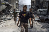 <p>An Iraqi member of the Counter-Terrorism Services (CTS) wearing a superman T-shirt walks in the Old City of Mosul on July 3, 2017 during an ongoing offensive to retake the city from Islamic State (IS) group fighters. (Photo: Fadel Senna/AFP/Getty Images) </p>