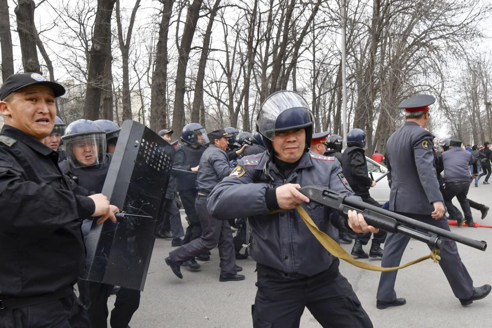 Kyrgyz police officers block the way for supporters of a jailed former parliament member, during a protest in Bishkek, Kyrgyzstan, Saturday, March 25, 2017. Supporters of a jailed former parliament member tried to break through a police cordon outside the national security agency's headquarters in Kyrgyzstan's capital, but police turned them back with flash grenades and arrested dozens. About 250 people had gathered in Bishkek to call for the release of Sadyr Jarapov, who was arrested when trying to enter the country earlier in the day. (AP Photo/Vladimir Voronin)