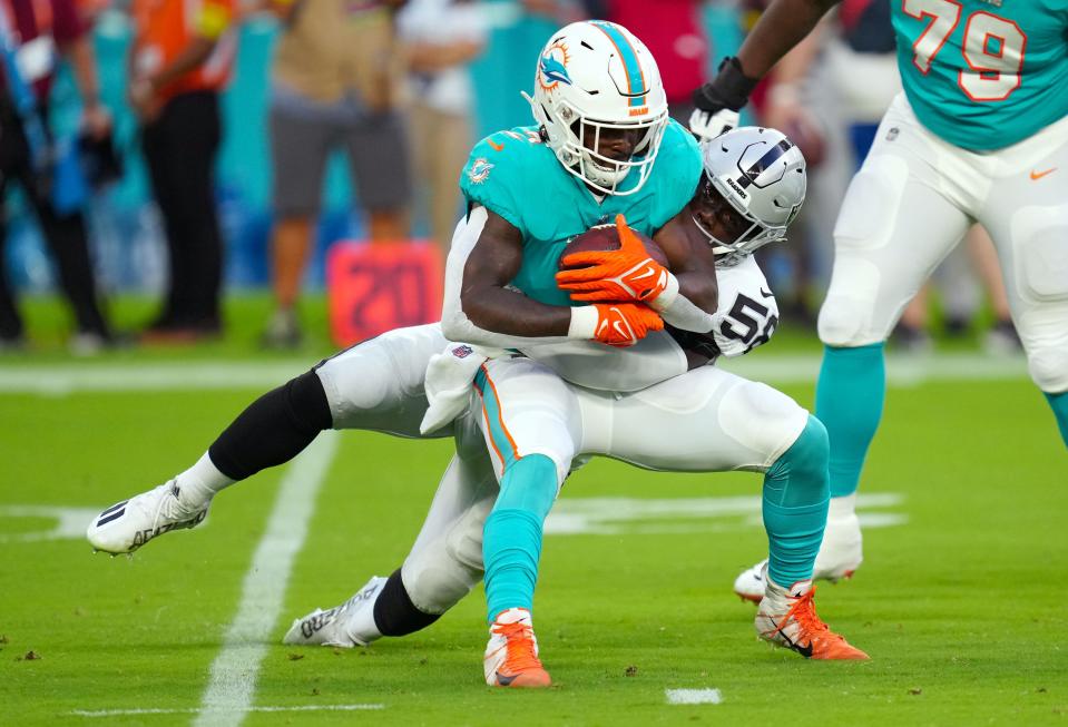 Raiders linebacker Darien Butler stops Dolphins running back Chase Edmonds.