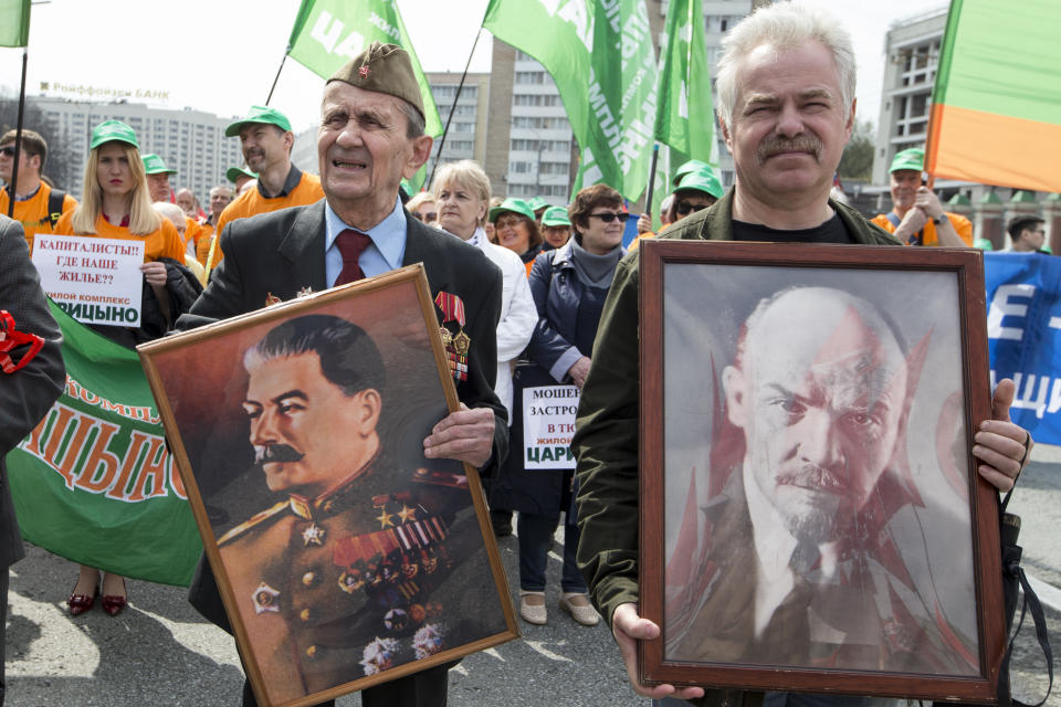 <p>Two elderly men carry portraits of Soviet founder Vladimir Lenin, right, and former Soviet leader Josef Stalin during a Communist rally to mark May Day in Moscow, Russia, May 1, 2018. Workers and activists marked May Day on Tuesday with rallies to demand their government address labor issues. (Photo: Alexander Zemlianichenko/AP) </p>