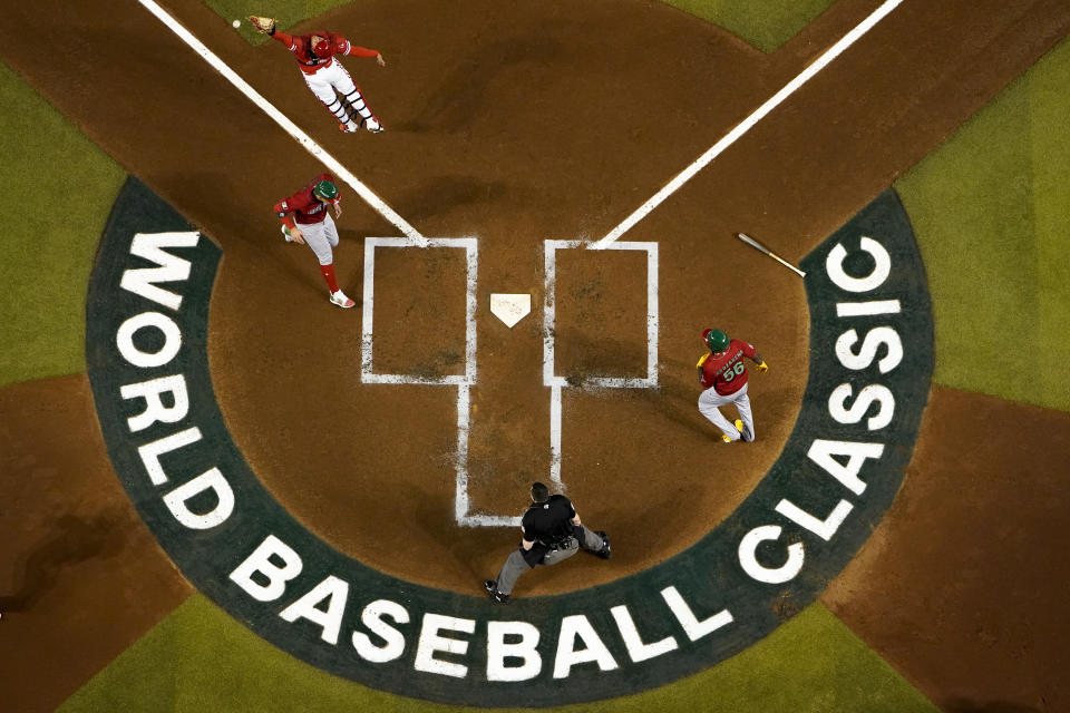 FILE - Mexico's Joey Meneses, left, and Randy Arozarena (56) score as Canada catcher Bo Naylor, top left, tries to catch a throw from right field after a single by Ryan Téllez during the first inning of a World Baseball Classic game in Phoenix, Wednesday, March 15, 2023. Major League Baseball is heading south of the border again to play a regular season series. After previous stops in Monterrey, Mexico City will be the host this time, and the timing seems perfect.(AP Photo/Godofredo A. Vásquez, File)