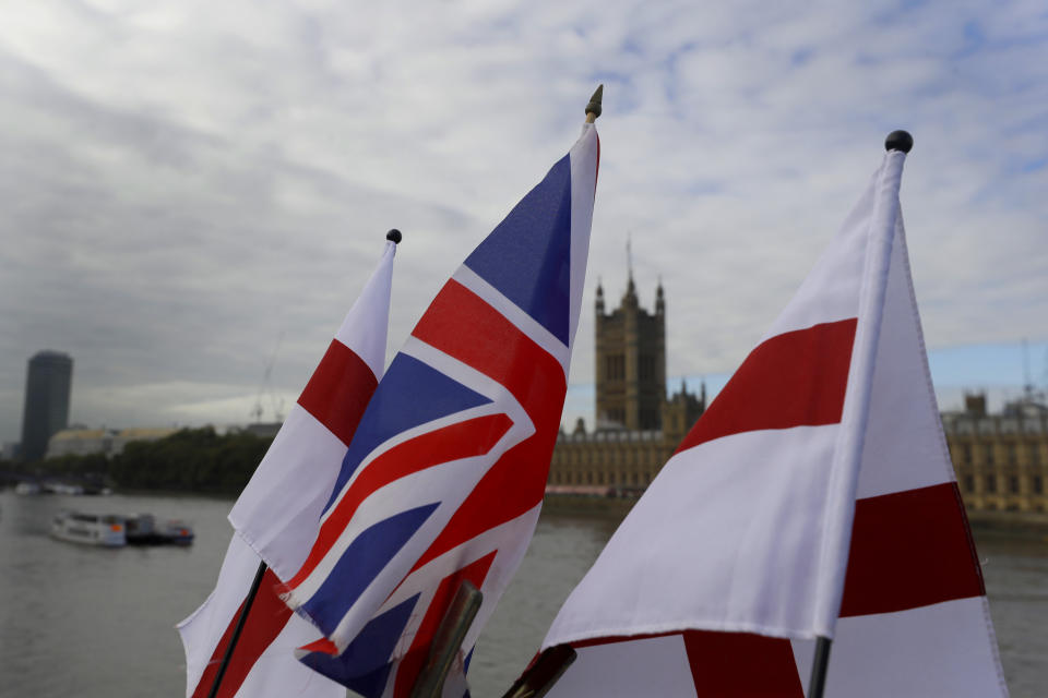 English flags and a Union flag fly above a souvenir stand opposite Britain's Parliament in London, Friday, Oct. 16, 2020. Britain’s foreign minister says there are only narrow differences remaining in trade talks between the U.K. and the European Union. But Dominic Raab insists the bloc must show more “flexibility” if it wants to make a deal. (AP Photo/Kirsty Wigglesworth)