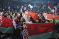 Women with Belarusian State flags react listening to Belarusian President Alexander Lukashenko during a women's forum in Minsk, Belarus, Thursday, Sept. 17, 2020. President Alexander Lukashenko's decision to close the borders with Poland and Lithuania underlines his repeated claim that the massive wave of protests is driven by the West and comes amid increasing criticism from the United States and the European Union. (TUT.by via AP)