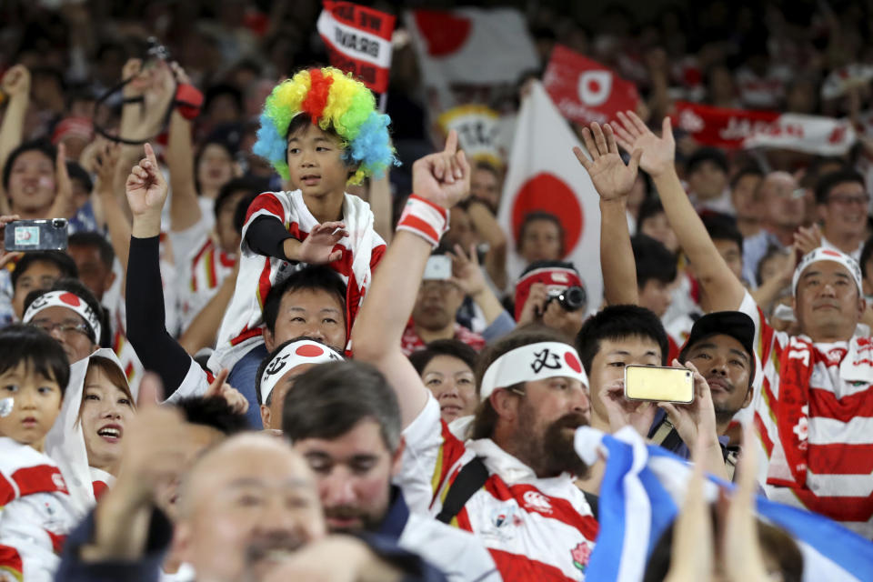 Fans celebrate after Japan won over Scotland in the Rugby World Cup Pool A game at International Stadium in Yokohama, Japan, Sunday, Oct. 13, 2019. (AP Photo/Eugene Hoshiko)