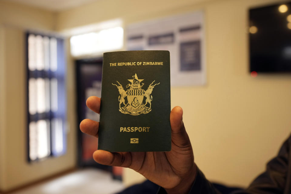 A traveler shows his passport he collected from the passport offices in Harare, Friday, Dec. 22, 2023. Atop many Christmas wish lists in economically troubled Zimbabwe is a travel document and people are flooding the passport office this holiday season ahead of a price hike planned in the New Year. The desperation at the office in the capital is palpable as some people fear the hike could push the cost of obtaining a passport out of reach and economic gloom feeds a surge in migration. (AP Photo/Tsvangirayi Mukwazhi)