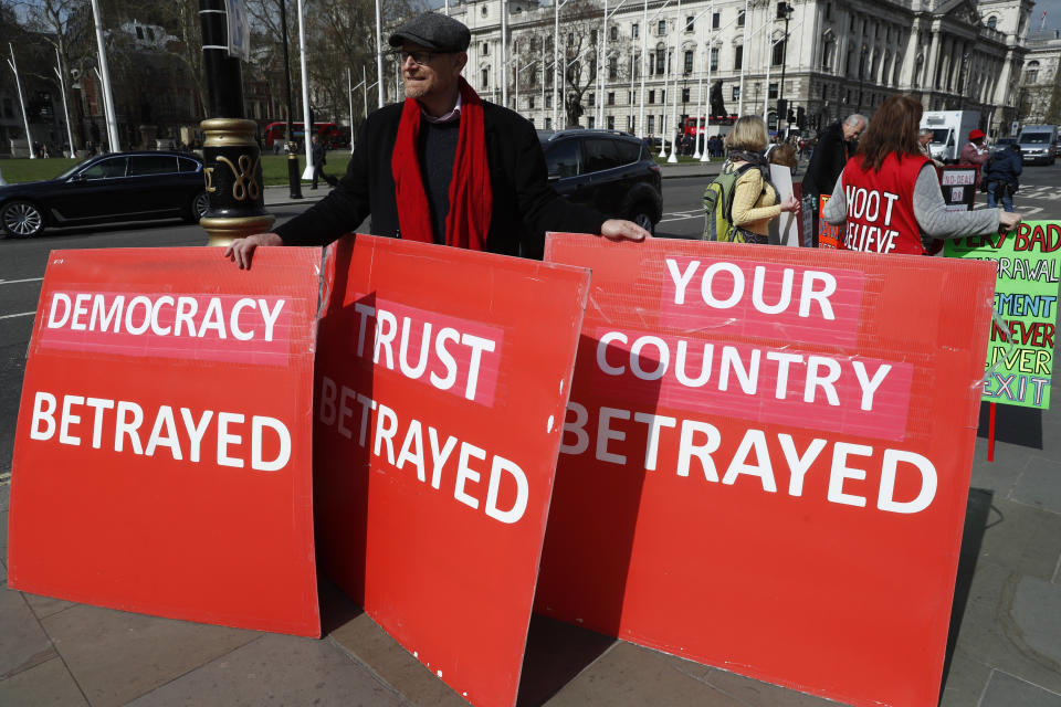 A pro-Brexit protester holds onto placards as he demonstrates near the House of Parliament in London, Tuesday, March 26, 2019. British Prime Minister Theresa May's government says Parliament's decision to take control of the stalled process of leaving the European Union underscores the need for lawmakers to approve her twice-defeated deal. (AP Photo/Alastair Grant)