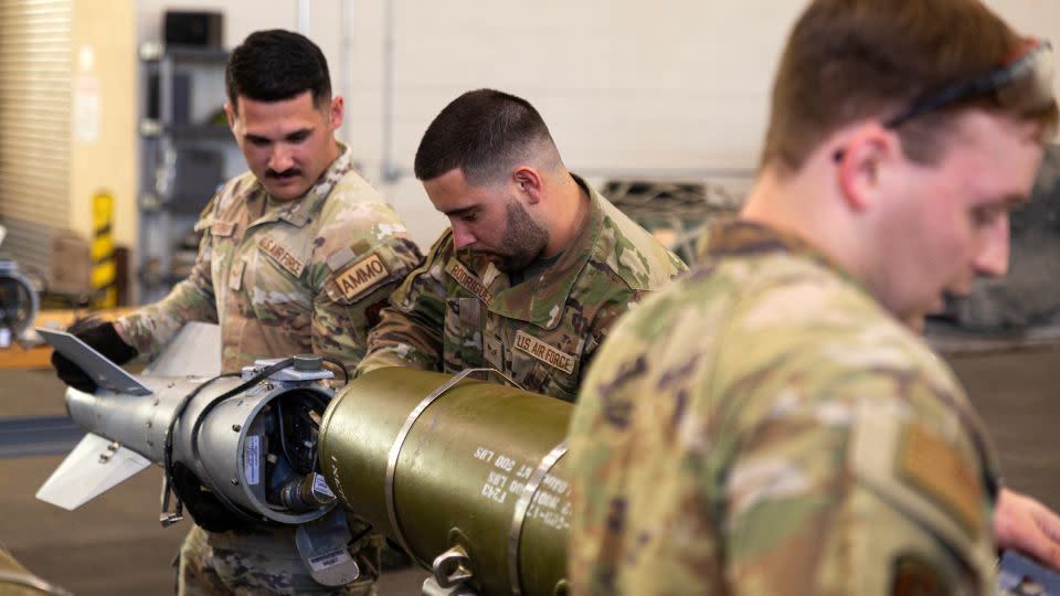 Airman Avery Bulsterbaum, left, Senior Airman Andrew Rodriguez, center, and Senior Airman Justin Joyner, right, practice assembling precision 500 pound bombs as part of the munitions teams. - Oren Liebermann/CNN