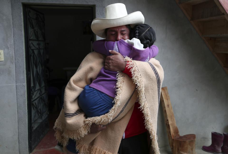 FILE - Free Peru party presidential candidate Pedro Castillo hugs his daughter Alondra who cries for him not to leave home, as he prepares to campaign in Chugur, Peru, April 15, 2021. After a year in office, President Pedro Castillo has seen his poll number fall as his administration has been beset by a myriad of troubles, ranging from accusations of corruption to having parliament attempt to remove him twice from office. (AP Photo/Martin Mejia, File)