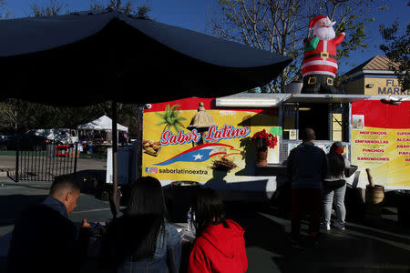 People buy food from a Puerto Rican food truck in Kissimmee, Florida, U.S., December 10, 2017. REUTERS/Alvin Baez